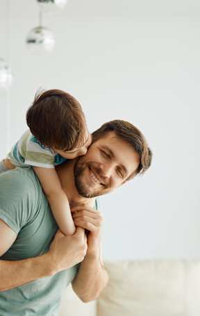 A man is holding a child up in the air.