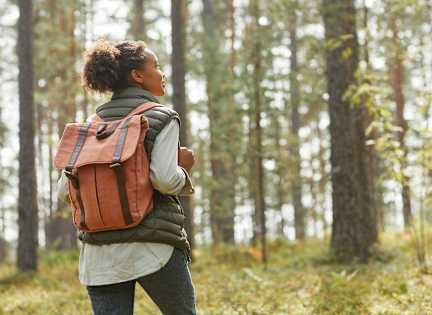 A person with a backpack is walking in a forest at Village at Almand Creek, Conyers, Georgia