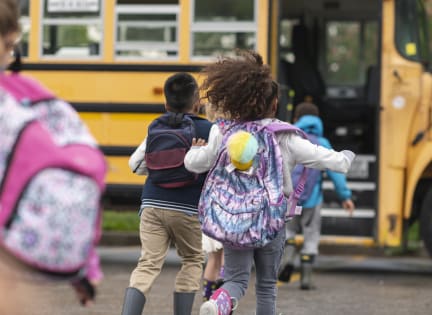 a group of children running to a school bus at Lory of Harbison, Columbia, SC