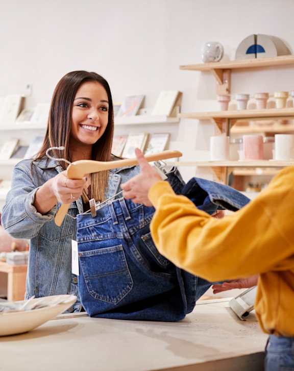 A woman is shopping in a store with a variety of items on display.