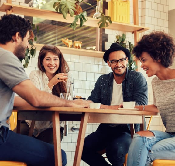 a group of people sitting around a table in a restaurant