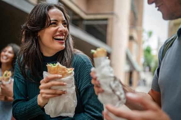 A woman is laughing while holding a burrito at Reserve At Settlers Ridge Apartments, Minnesota, 55129