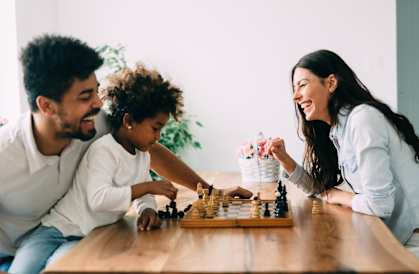 a family playing a game of chess in their living room