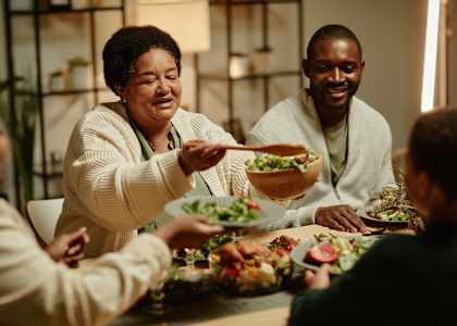 A group of people are gathered around a table enjoying a meal together.