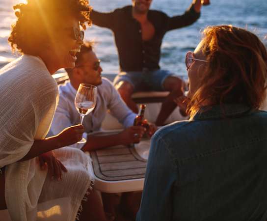 a group of people sitting around a table on a boat at The Standard, Charleston, SC, 29412