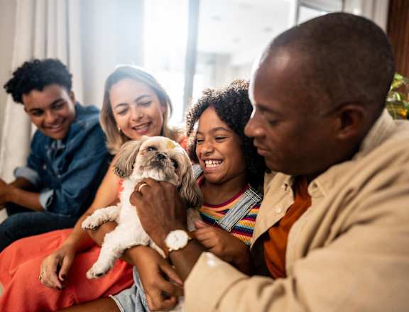 A family is sitting together with a dog.