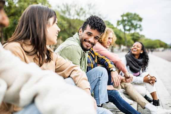 A group of people are sitting on a bench outside at Apex, Colorado Springs, CO