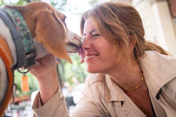 A woman is petting a dog on the head.