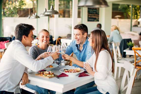 A Group of People Toasting at a Restaurant Table at Capitol Grove Apartments, Iowa