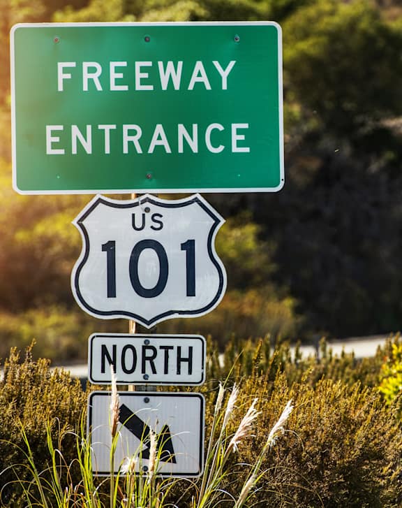 A sign indicates the entrance to a freeway.