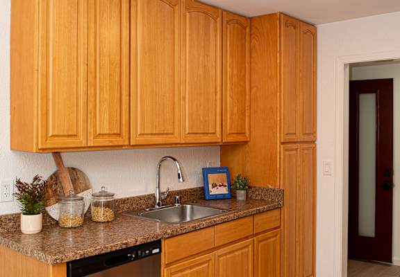 A kitchen with wooden cabinets and a granite countertop.