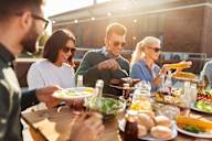 A group of people enjoying a meal together at an outdoor table.
