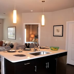 A modern kitchen with a dining area and a living room.