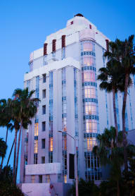 a view of the los angeles times building at dusk with palm trees in the foreground