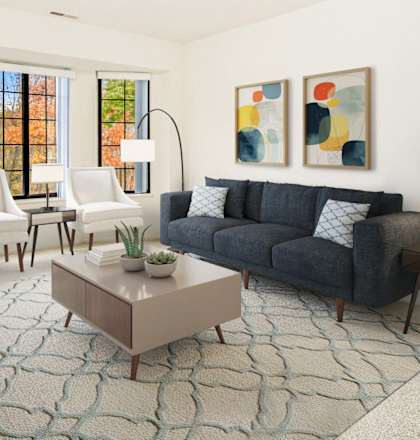 A living room with a blue couch, a coffee table, and a painting on the wall at Tanglewood Apartments, Oak Creek