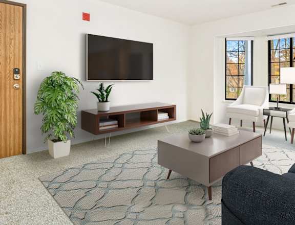 A living room with a flat screen TV mounted on the wall at Tanglewood Apartments, Oak Creek