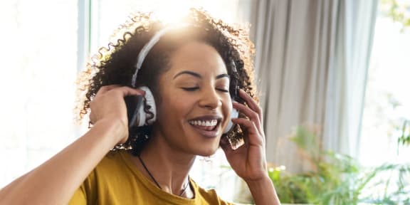 a woman sitting on a couch wearing headphones