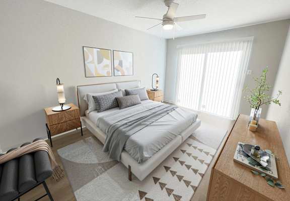 A bedroom with a large bed, a ceiling fan, and a chair.