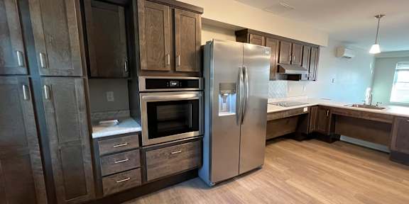 A kitchen with a black counter top and a white fridge.