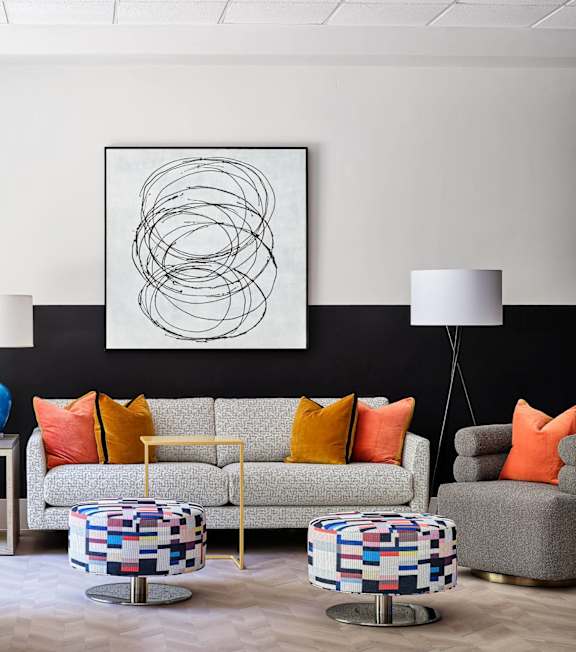 A modern living room with a pool table and a large abstract painting on the wall.