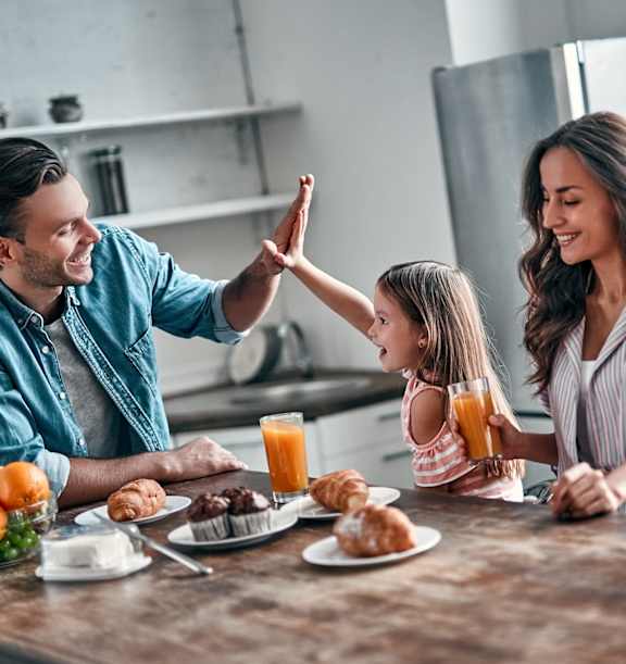 A family is having breakfast together in a kitchen.