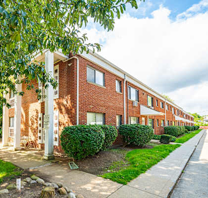 a brick apartment building with a sidewalk in front of it