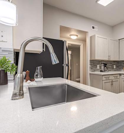 Sleek kitchen featuring light wood cabinetry, stainless steel appliances, and quartz countertops.