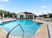 Thumbnail 15 of 16 - A large swimming pool in front of a building with a white roof at The Teale Siesta Lago in Kissimmee, FL, 34746
