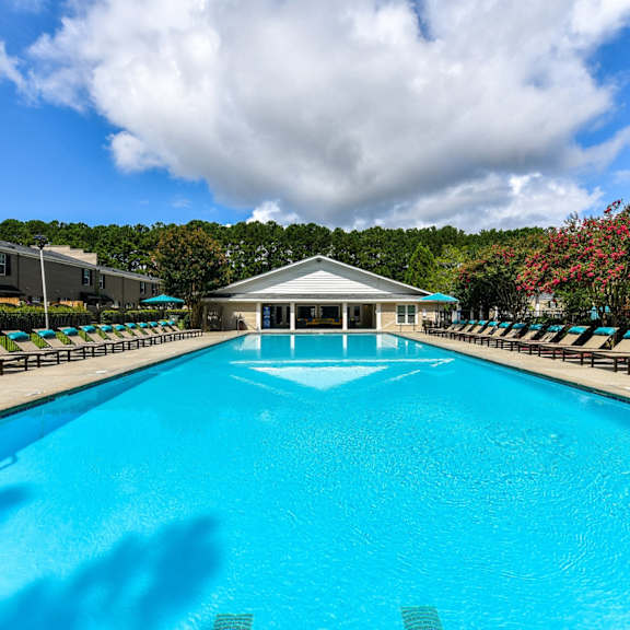 A swimming pool surrounded by a brick border and a metal fence.