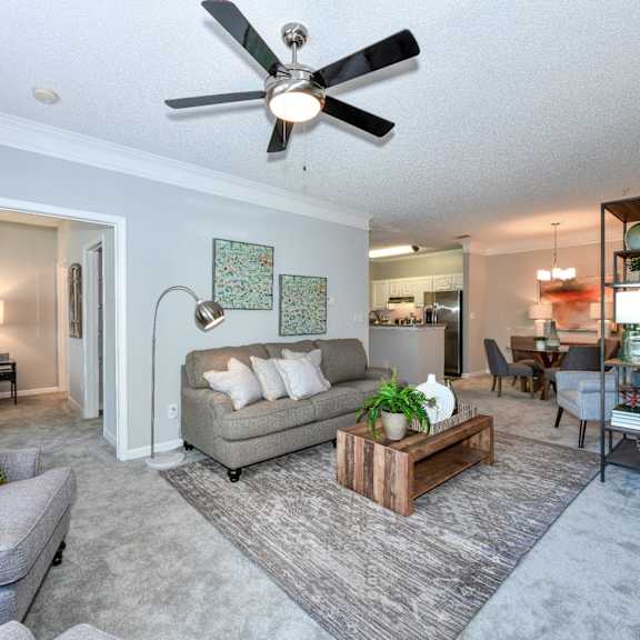 a living room with a ceiling fan and couches