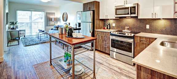 A kitchen with a wooden island and stainless steel appliances.