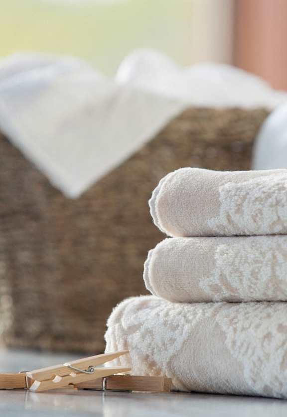 a basket of towels on a table with a detergent bottle