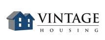 A logo for vintage housing features a blue house and the words "Vintage Housing" in black.
