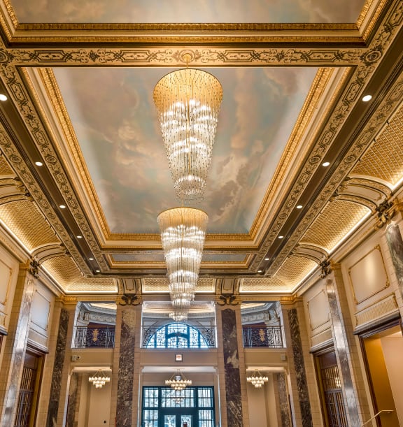 the lobby of a building with a large ceiling and a chandelier at the Belden Stratford in Chicago, Illinois 60614