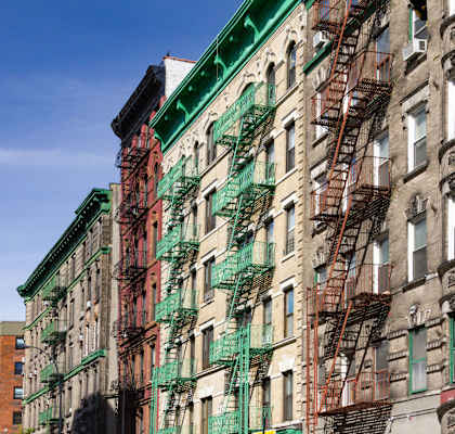 A row of old buildings with fire escapes on the side.