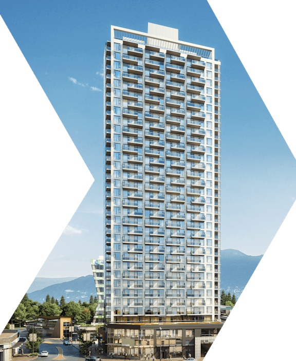 A tall building with many windows stands in front of a mountain.