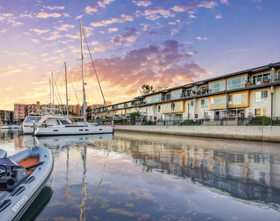 a marina with boats docked in front of a row of apartments at Marina Harbor, California, 90292