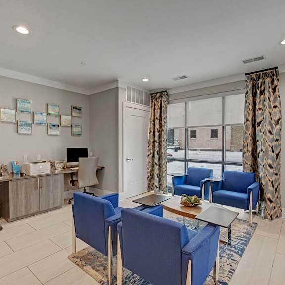 Business Center with WiFi The business center at River House Apartment Homes with blue chairs and desktop monitors.