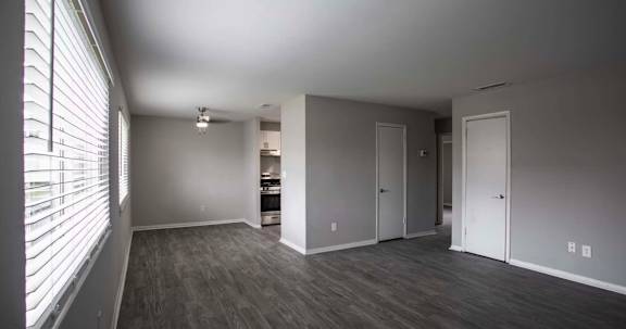 a living room with a large window and wood flooring