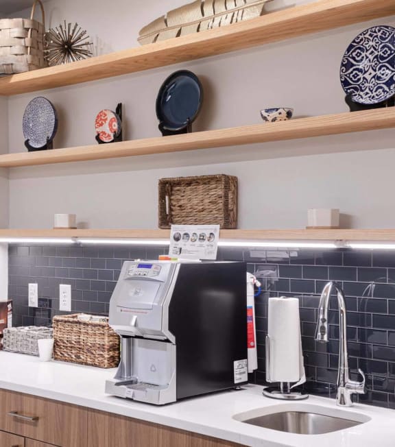 a kitchen with a sink and a coffee maker