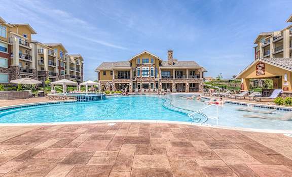 a large swimming pool with an apartment building in the background at WaterCrest at City Center, Lenexa, KS, 66219