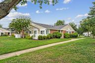 A house with a white fence and a green lawn.