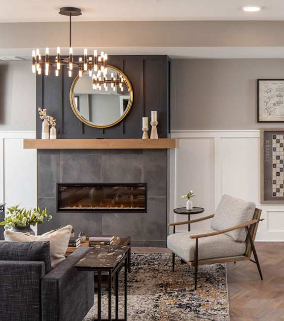 A living room with a fireplace and a chandelier. at The Edison at Rice Creek I and II, Minnesota, 55126