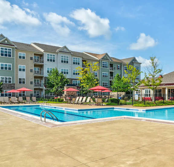 a swimming pool with an apartment building in the background