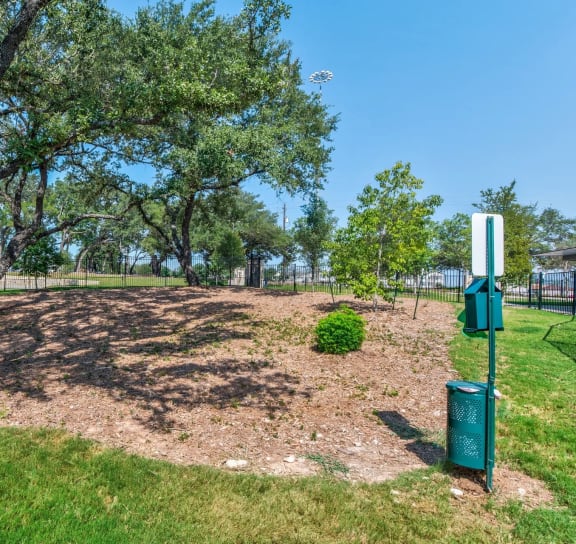 a park with a tree and a sign in the grass