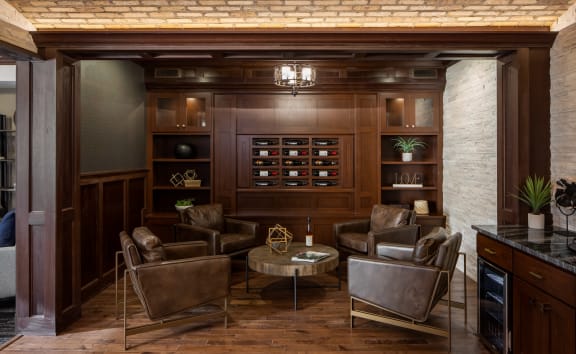 a living room with leather chairs and a bar