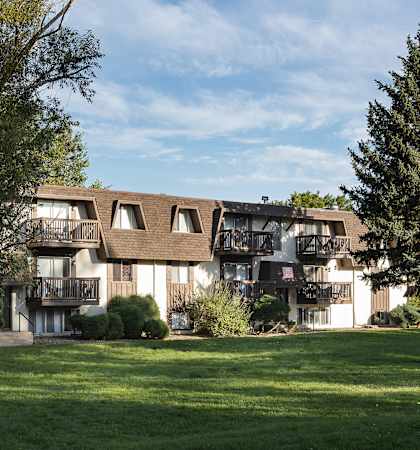 A large building with a balcony and a tree in front of it.