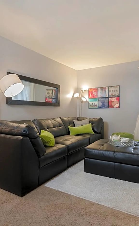 a living room with a leather couch and a large window
