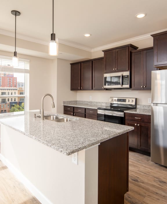 a kitchen with a marble counter top and a stainless steel refrigerator