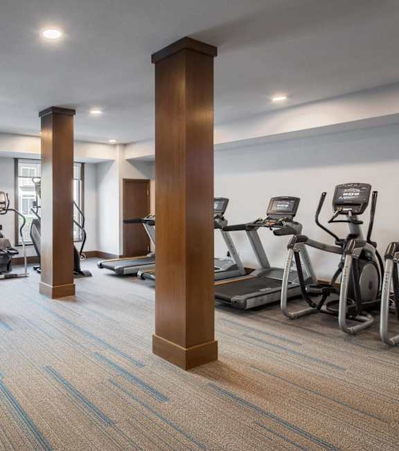 A gym with a variety of equipment including treadmills, weights, and exercise machines.at The Edison at Spirit, Lakeville, MN